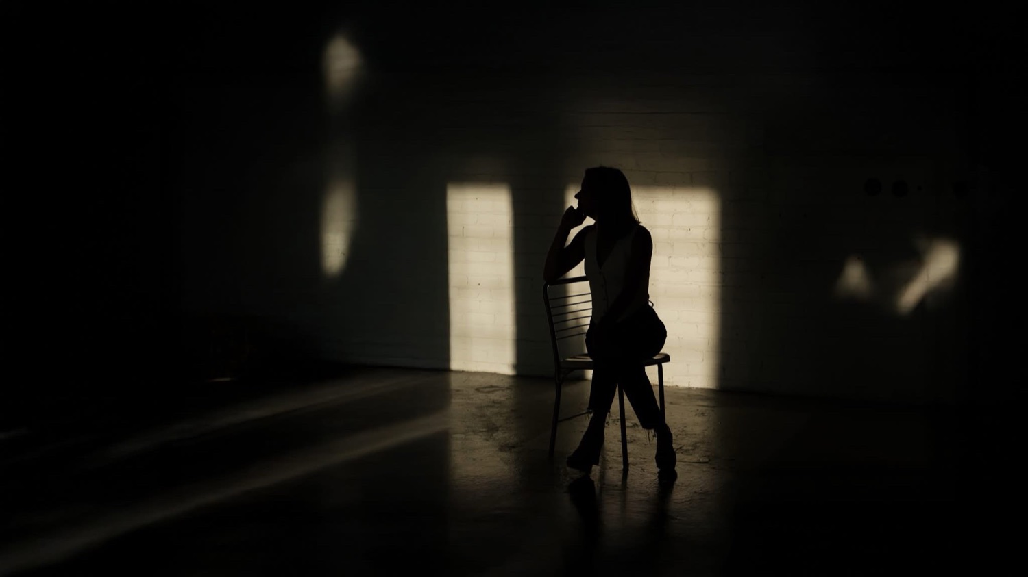 Angie Carel, seated in a spotlit studio
